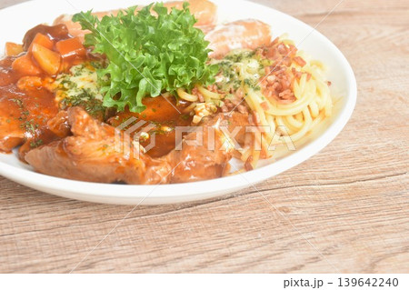 grilled pork steak dressing sweet and sour gravy stew sauce with spaghetti and chop cabbage salad couple sausage on plate  139642240