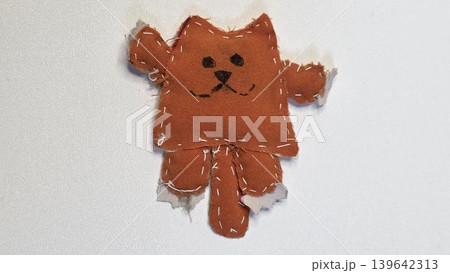 Handmade stitched orange fabric cat toy isolated on white background. Cute clumsy diy craft project made by child representing creative naive textile art and childish imagination. Handmade stitched orange fabric cat toy isolated on white background. Cute clumsy diy craft project made by child representing creative naive textile art and childish imagination. 139642313