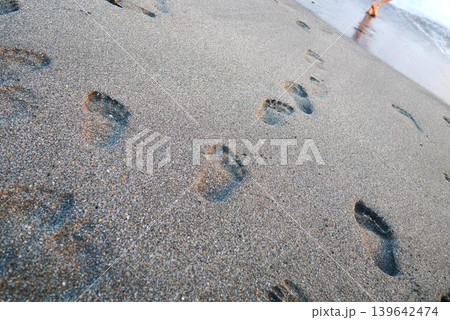 砂浜に残る足跡｜海辺を歩く夏の思い出イメージ 139642474