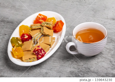 Cup of tea and a plate with fruit sweets and chocolate. Cup of tea and a plate with fruit sweets and chocolate. 139643230