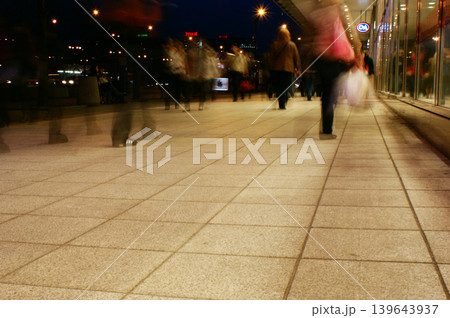 a group of people walking along the sidewalk promenade long exposure at night a group of people walking along the sidewalk promenade long exposure at night 139643937