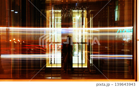 long exposure time reflected in the glass in the city cars are moving fast long exposure time reflected in the glass in the city cars are moving fast 139643943