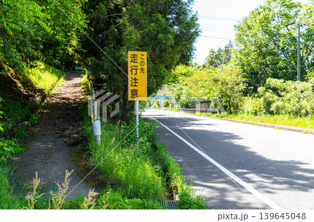 「走行注意」看板と、緑に包まれた道路 「走行注意」看板と、緑に包まれた道路 139645048
