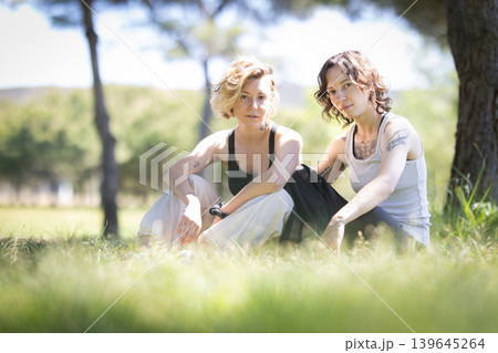 Two young women relaxing in park on grass Two young women relaxing in park on grass 139645264