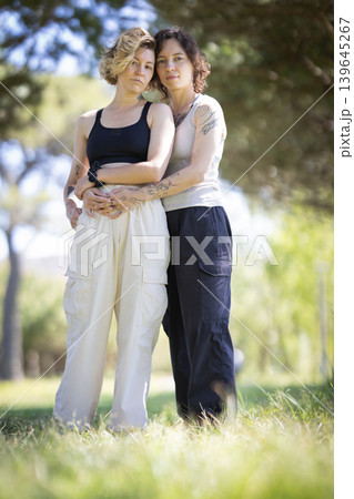 Loving lesbian couple embracing outdoors showing affection Loving lesbian couple embracing outdoors showing affection 139645267
