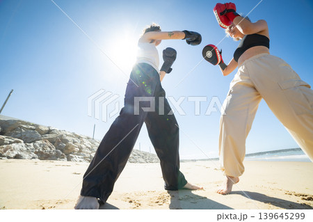 Women training kickboxing on beach for fitness and strength 139645299