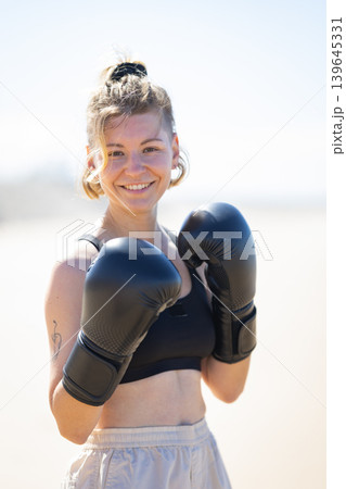 Young woman smiling ready for boxing training outdoors 139645331