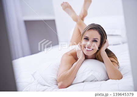 Woman, lazy and happy on bed in portrait, peace and comfortable on morning at home. Female person, smiling and satisfaction while resting in bedroom, wake up and good mood on vacation or holiday Woman, lazy and happy on bed in portrait, peace and comfortable on morning at home. Female person, smiling and satisfaction while resting in bedroom, wake up and good mood on vacation or holiday 139645379