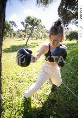 Young woman boxing in a park for fitness training Young woman boxing in a park for fitness training 139645411