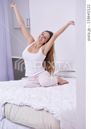 Woman, happy and stretching in bed on weekend, lazy and comfortable on morning at home. Female person, smiling and satisfaction while resting in bedroom, wake up and good mood on vacation or holiday 139645522