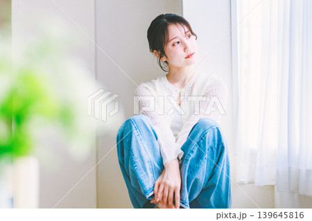 椅子に座るジーンズの若い女性 椅子に座るジーンズの若い女性 139645816