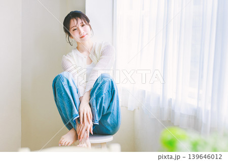 椅子に座るジーンズの若い女性 椅子に座るジーンズの若い女性 139646012