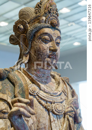 Abu Dhabi, United Arab Emirates - Jan 17 2024, Close up view of the face of the wooden statue of the Bodhisattva of compassion, on exhibition of museum Louvre Abu Dhabi, UAE Abu Dhabi, United Arab Emirates - Jan 17 2024, Close up view of the face of the wooden statue of the Bodhisattva of compassion, on exhibition of museum Louvre Abu Dhabi, UAE 139647316