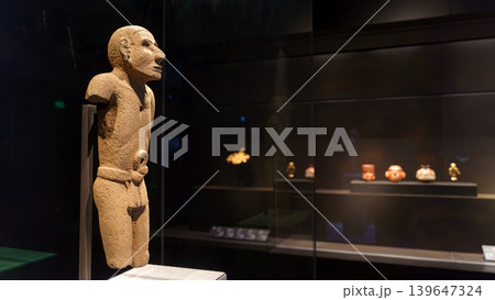 Abu Dhabi, United Arab Emirates - Jan 17 2024, close-up view of the stone Aztec sculpture of a man, in the background there are other exhibits of the museum Louvre Abu Dhabi, UAE 139647324