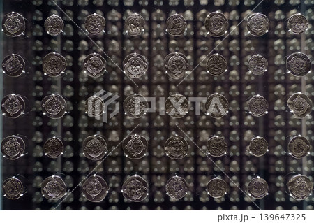 Abu Dhabi, United Arab Emirates - Jan 17 2024, Close-up view of showcase with many antique coins with a mirror reflecting them many times, Louvre Abu Dhabi Museum, Abu Dhabi, United Arab Emirates 139647325
