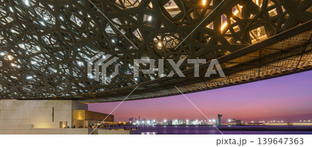 Abu Dhabi, United Arab Emirates - Jan 17 2024, Panoramic sea view of the port from under the metallic dome of the Louvre Abu Dhabi, at sunset, Abu Dhabi, United Arab Emirates Abu Dhabi, United Arab Emirates - Jan 17 2024, Panoramic sea view of the port from under the metallic dome of the Louvre Abu Dhabi, at sunset, Abu Dhabi, United Arab Emirates 139647363