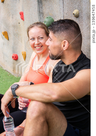 Mature woman smiling at fitness partner after outdoor climbing workout 139647458