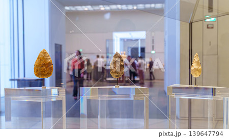 Abu Dhabi, United Arab Emirates - Jan 17 2024, Close-up view of three ancient flint blades, the background is blurred, on exhibition of the Louvre Abu Dhabi, UAE 139647794