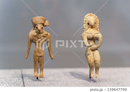 Abu Dhabi, United Arab Emirates - Jan 17 2024, Close-up view of two ancient statuettes of women, deities, with necklace, on exhibition of museum Louvre Abu Dhabi, UAEe 139647799