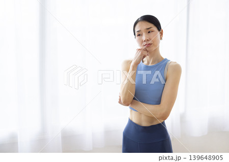 明るい窓辺で困った表情をする日本人女性 明るい窓辺で困った表情をする日本人女性 139648905