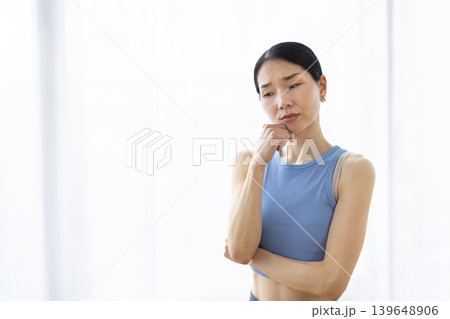 明るい窓辺で困った表情をする日本人女性 明るい窓辺で困った表情をする日本人女性 139648906