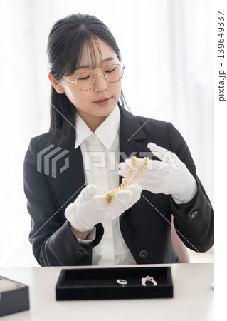 貴金属を鑑定する日本人女性 査定員 中古買取 リサイクルショップ 白手袋 139649337