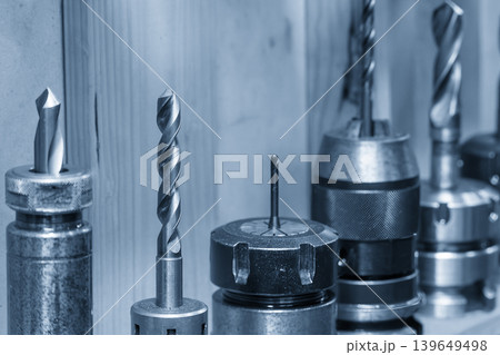 Collection of professional high-speed steel twist drills and countersink bits in an organized tool holder, prepared for a metalworking drilling process in an industrial workshop. Collection of professional high-speed steel twist drills and countersink bits in an organized tool holder, prepared for a metalworking drilling process in an industrial workshop. 139649498