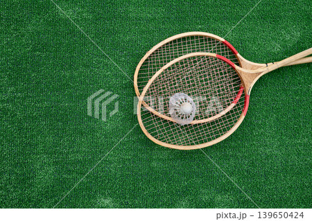 Vintage badminton rackets and shuttlecock on green grass top view 139650424