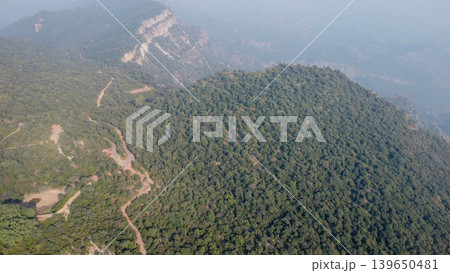 Tilla jogian hill covered in trees with winding dirt road leading to summit pakistan Tilla jogian hill covered in trees with winding dirt road leading to summit pakistan 139650481