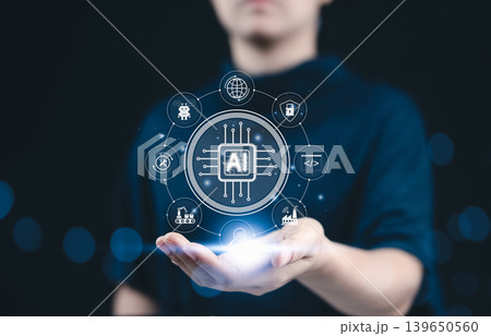 AI, artificial intelligence concept. A hand holding a glowing AI icon surrounded by futuristic interface elements and technology-related symbols, representing artificial intelligence innovation. AI, artificial intelligence concept. A hand holding a glowing AI icon surrounded by futuristic interface elements and technology-related symbols, representing artificial intelligence innovation. 139650560