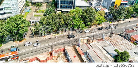 View of a city intersection with office buildings and traffic during the day View of a city intersection with office buildings and traffic during the day 139650755