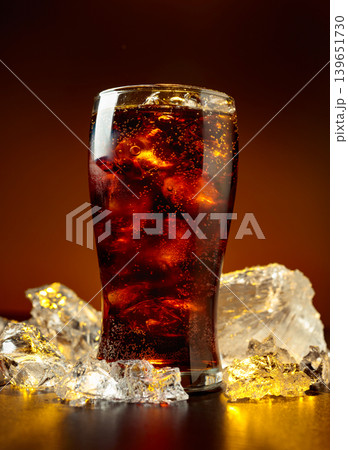 Fizz sparkling cola bubbly soda pop with crushed ice on a black table. Fizz sparkling cola bubbly soda pop with crushed ice on a black table. 139651730