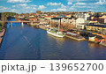 Porvoo, Finland - December 08, 2020: Scenic view of a river with boats, surrounded by colorful buildings and a clear blue sky, showcasing a vibrant urban landscape 139652700