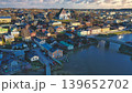 Porvoo, Finland - December 08, 2020: Aerial view showcases a vibrant town along the river, featuring colorful houses, a bridge, and scenic landscapes under a cloudy sky 139652702