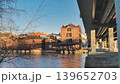 Porvoo, Finland - December 08, 2020: Historic wooden structures line the riverbank, with a bridge overhead creating a unique urban landscape and inviting atmosphere 139652703