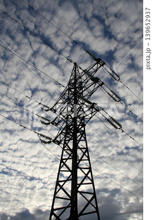 Steel transmission tower and wires of high voltage power line over cloudy sky Steel transmission tower and wires of high voltage power line over cloudy sky 139652937