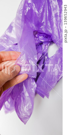 Plastic bags shown in hand highlight pollution from non degradable materials Plastic bags shown in hand highlight pollution from non degradable materials 139652943
