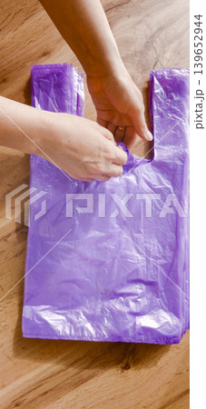 Plastic bags being handled in a room, highlighting pollution issues on Earth 139652944