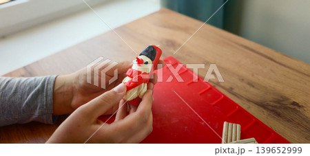 Child makes a snowman out of plasticine in a bright room on a winter day Child makes a snowman out of plasticine in a bright room on a winter day 139652999
