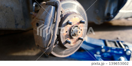 Replacing brake discs and drums during car repair process at a garage workshop Replacing brake discs and drums during car repair process at a garage workshop 139653002