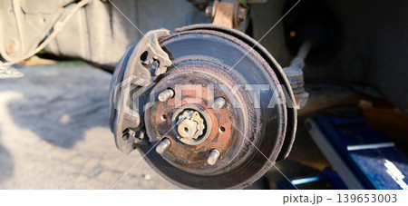 Brake disc and drum during car suspension repair in auto repair shop Brake disc and drum during car suspension repair in auto repair shop 139653003