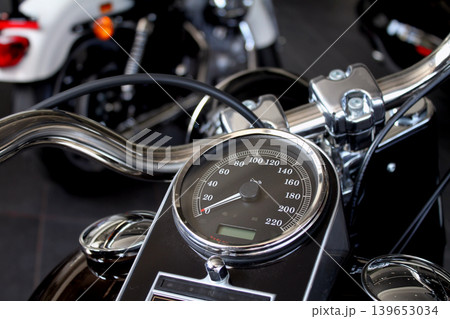 Speedometer and chrome parts on motorcycle handlebar in motorbike shop 139653034