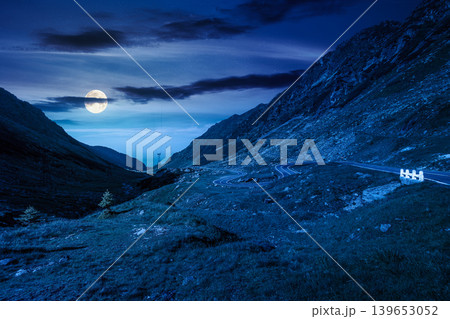 road through mountains winding uphill at night. full moon over popular highway travel destination of Romania. mysterious view of mountain on summertime weather. road journey landscape road through mountains winding uphill at night. full moon over popular highway travel destination of Romania. mysterious view of mountain on summertime weather. road journey landscape 139653052