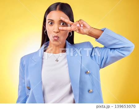 Business woman, peace sign and studio portrait with funny face, pouting and emoji by yellow background. Entrepreneur, hand and eye with kiss, comic face and icon for vote, opinion or crazy gesture 139653070
