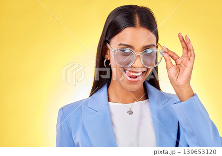 Funny, woman and sunglasses with tongue out, comedy and silly face in a studio. Yellow background, crazy and young female person with modern fashion, trendy cool style and creative work clothing 139653120