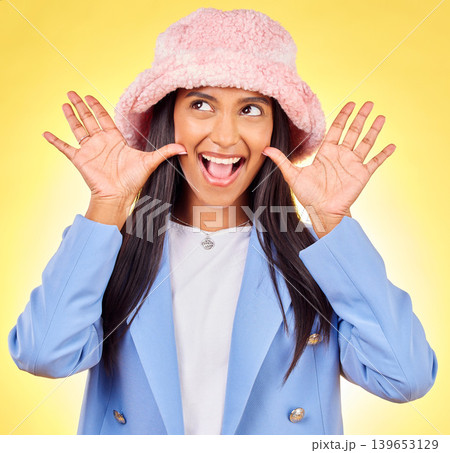 Fashion, surprise and face of Indian woman on yellow background with excited, goofy and playful pose. Emoji, happiness and person in studio with hand gesture in trendy accessories, style and hat Fashion, surprise and face of Indian woman on yellow background with excited, goofy and playful pose. Emoji, happiness and person in studio with hand gesture in trendy accessories, style and hat 139653129
