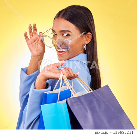 Shopping, fashion and portrait of woman as a customer happy for retail isolated in a studio yellow background. Smile, product and sale for young person with style discount, deal and promo on clothes Shopping, fashion and portrait of woman as a customer happy for retail isolated in a studio yellow background. Smile, product and sale for young person with style discount, deal and promo on clothes 139653211