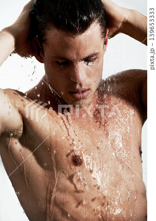 Man in shower with water splash, cleaning hair and body for morning wellness, hygiene and skin routine in home. Grooming, skincare and relax, male model washing with self care and calm in bathroom. 139653333