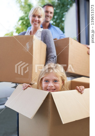 Moving, portrait and girl in box with parent, fun in new home and happy package with mortgage. Mother, father and playful child in cardboard with smile, hiding and property investment for family. 139653373