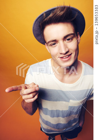 Portrait, hipster and man with fashion, pointing and confident guy on an orange studio background. Person, hand gesture and model with stylish clothes, hat and casual outfit with aesthetic and trendy Portrait, hipster and man with fashion, pointing and confident guy on an orange studio background. Person, hand gesture and model with stylish clothes, hat and casual outfit with aesthetic and trendy 139653383